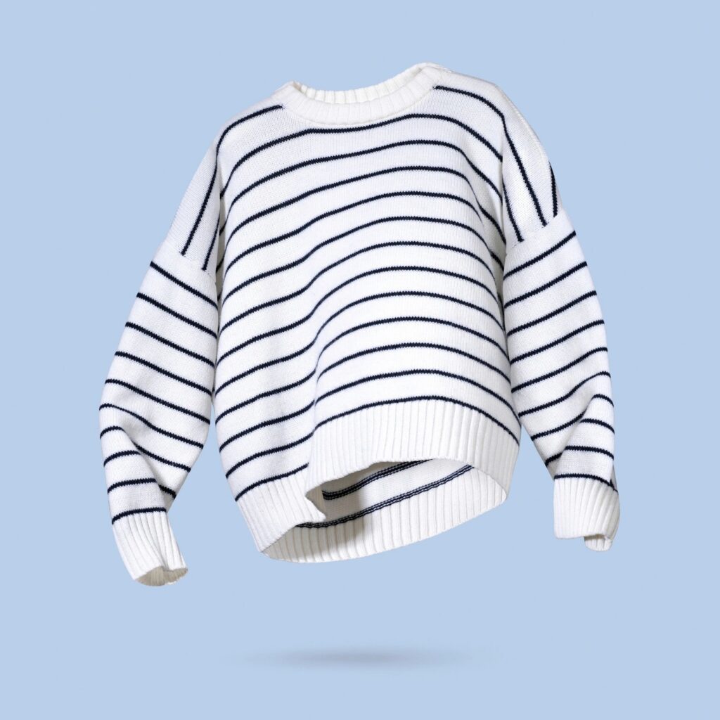 White and black striped flying women's autumn knitted sweater on light, pastel blue background. Concept of trendy clothing, creative fall winter cozy pullover. Fashion sale autumn discounts, shopping